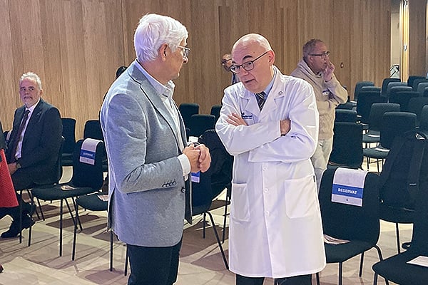 El ex conseller de Salut, Manel Balcells, conversando con Josep Tabernero, jefe del Servicio de Oncología del Hospital Vall d'Hebron.