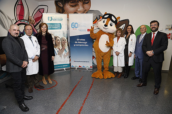 Juame Junque, CEO de Suite of Art; Julio García Pondal, director gerente del Hospital Universitario Puerta de Hierro; Celia García Menéndez, directora general de Humanización, Atención y Seguridad del Paciente en la Consejería de Sanidad; mascota del área de Pediatría; Enriqueta Román, jefa del Servicio de Pediatría del Hospital Puerta de Hierro; Begoña de Andrés, directora de Enfermería del Hospital Puerta de Hierro; Gabriel Núñez González, presidente de la Fundación Uniteco y presidente de Uniteco; y Juan Pablo Núñez, secretario general de la Fundación Uniteco.