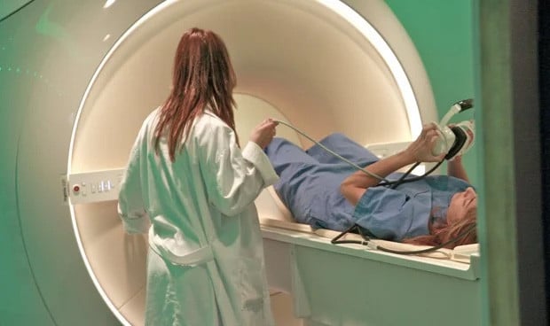 Paciente en un escáner PET-CT mientras una técnica en medicina nuclear supervisa el procedimiento en un hospital. Diagnóstico por imagen avanzado