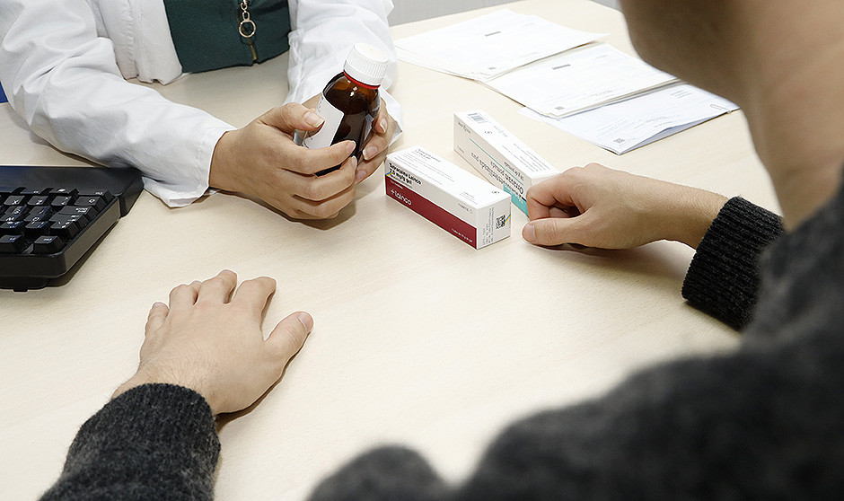 Médico prescribiendo medicación a un paciente.