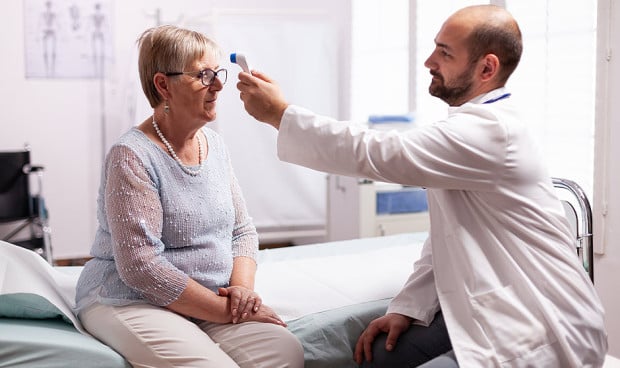 Médico tomando la temperatura a una paciente.