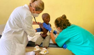 Dos profesionales sanitarios atienden a un niño en una consulta médica durante una misión de voluntariado de Fundación Recover en África Subsahariana.