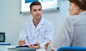 Un médico residente atiende a una paciente en su consulta. 